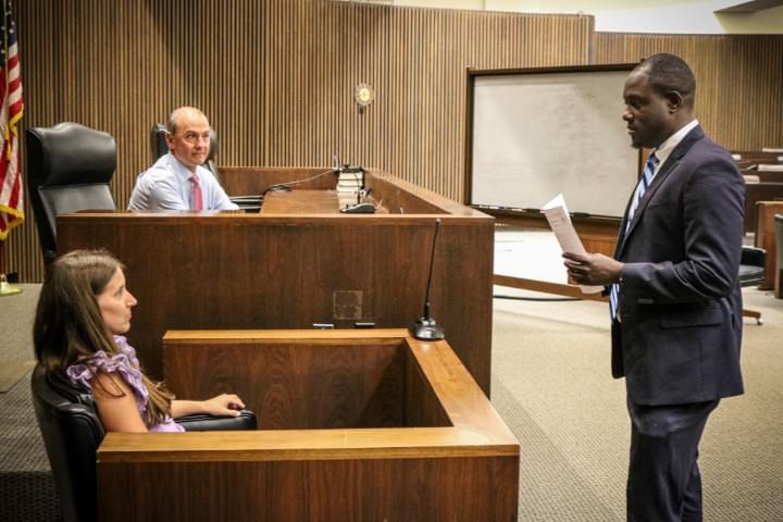 Judge witness and lawyer standing courtroom